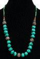 Collier ethnique artisanal imitation pierres turquoises difformes agence de petites perles noires et vertes ainsi que de grosses perles en metal