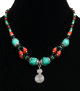 Collier ethnique artisanal imitation pierres turquoises agencees de perles multicouleurs et agremente de breloque spirale tourbillon en metal argente